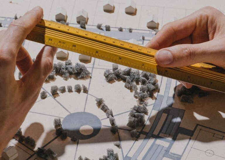 Zbliżenie dłoni mierzących model architektoniczny linijką